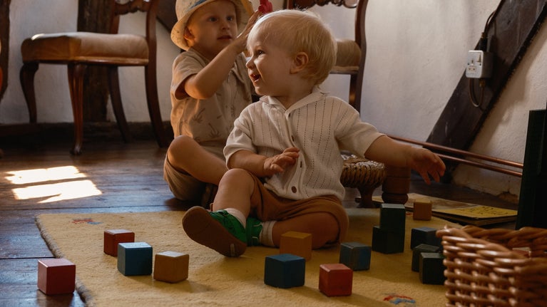Two children enjoy playing with traditional toys in the Solar room at Paycocke's House, Essex
